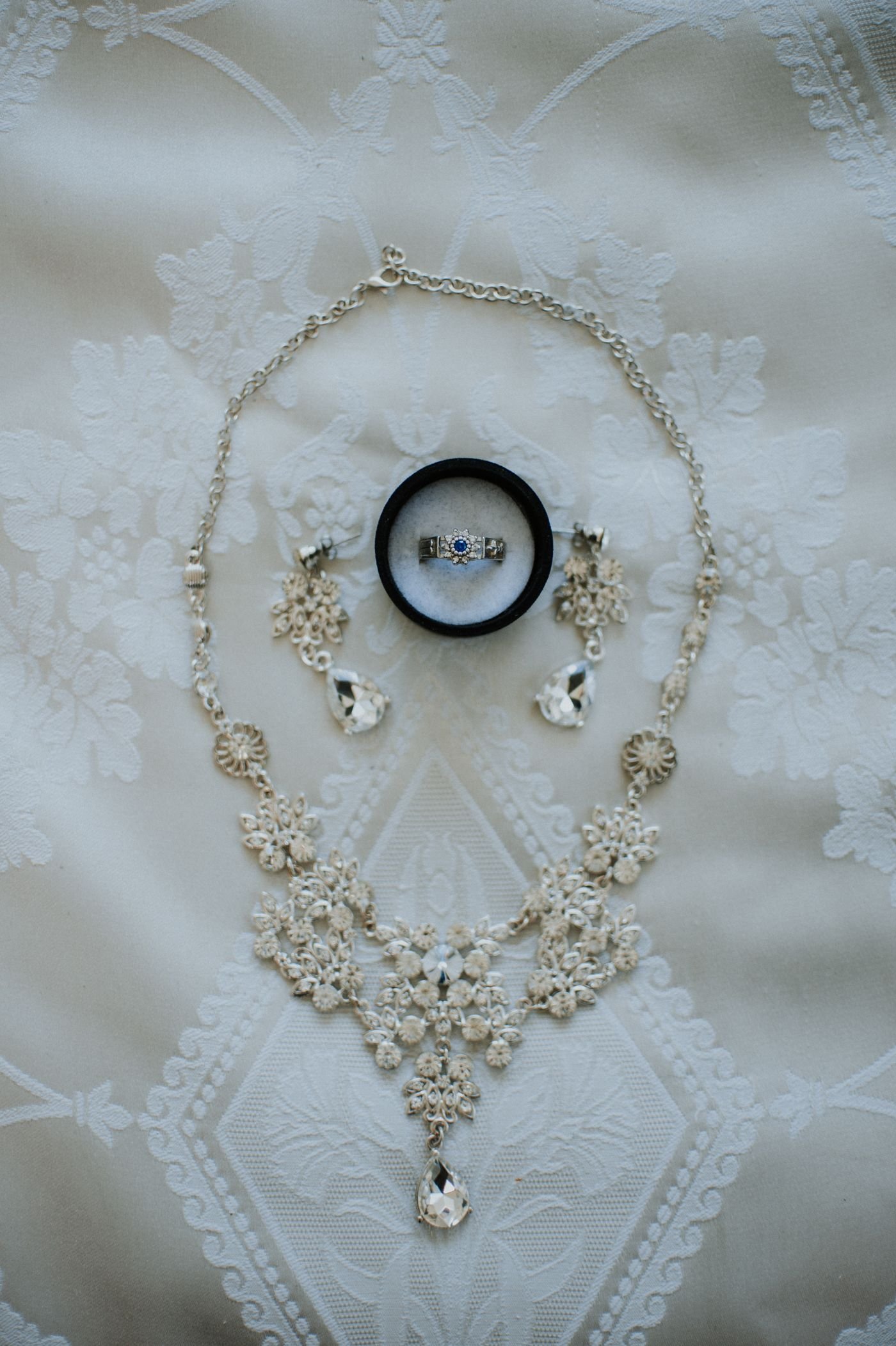 Illustrative gold necklace and earrings on a dark display