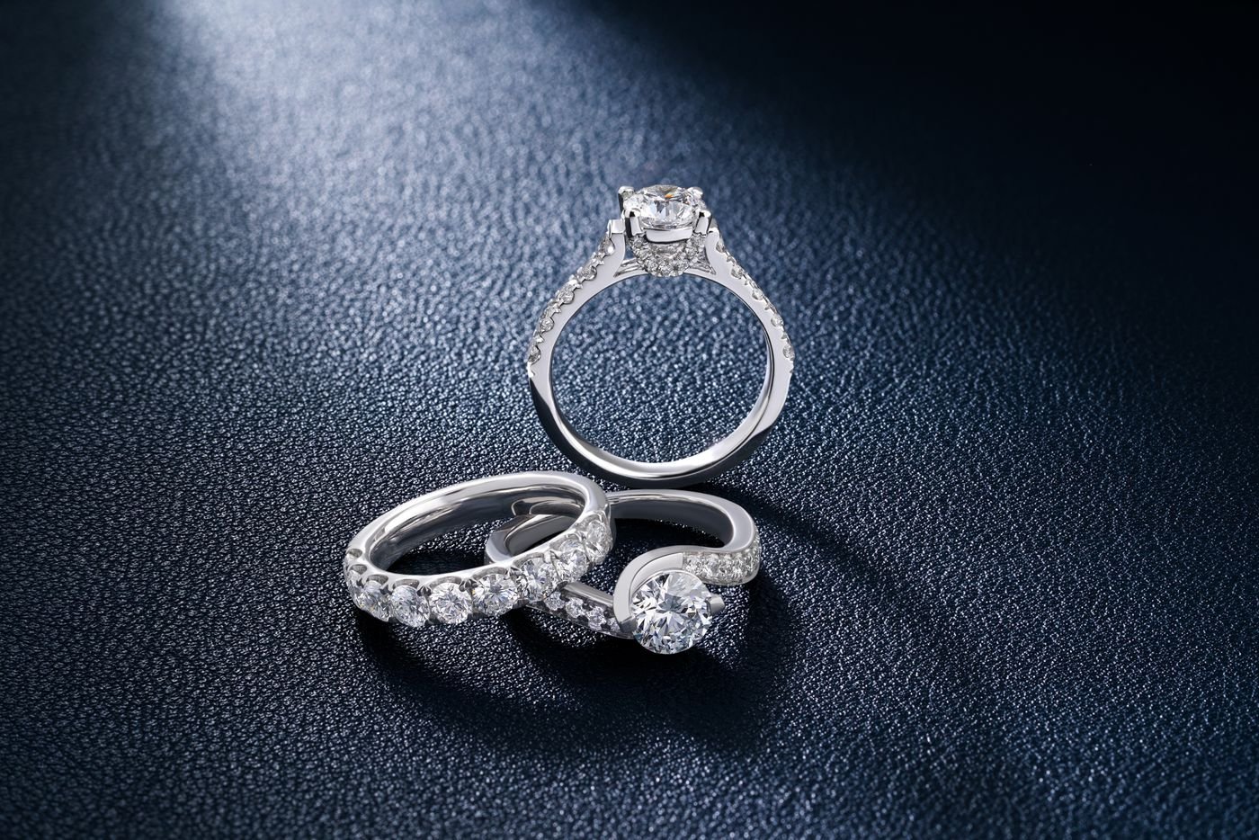 Illustrative close-up of diamond rings on a textured surface