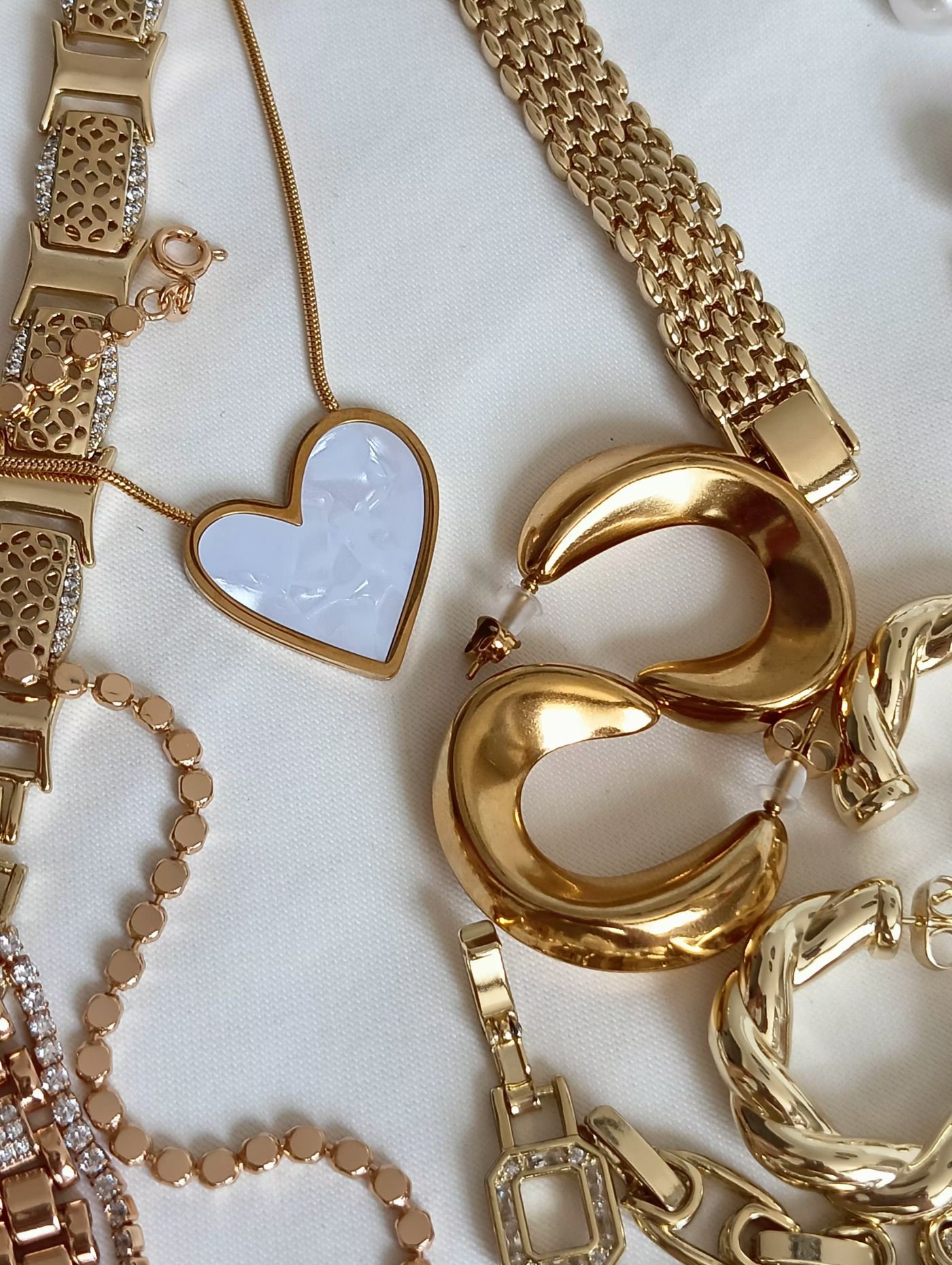 Mejuri Review: Is the Everyday Fine Jewelry Brand Worth It? 4 Illustrative flat lay of rings, earrings and a necklace